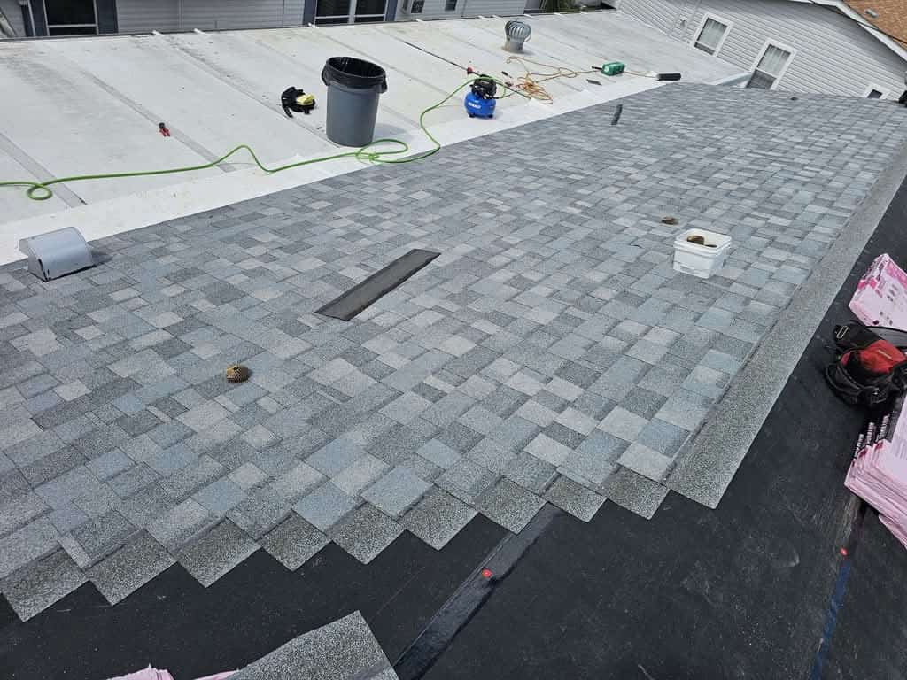 Architectural asphalt shingles installed in staggered courses over the new underlayment