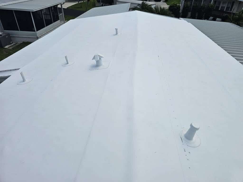Finished TPO roof with four sealed pipe boots and a vent cap flashed into the membrane